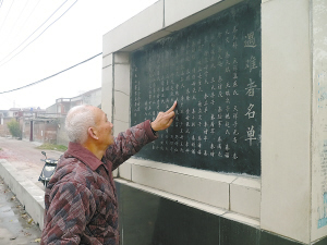 村民李广富从纪念碑上找着亲人的名字,想起76年前的秦庄惨案忍不住悲